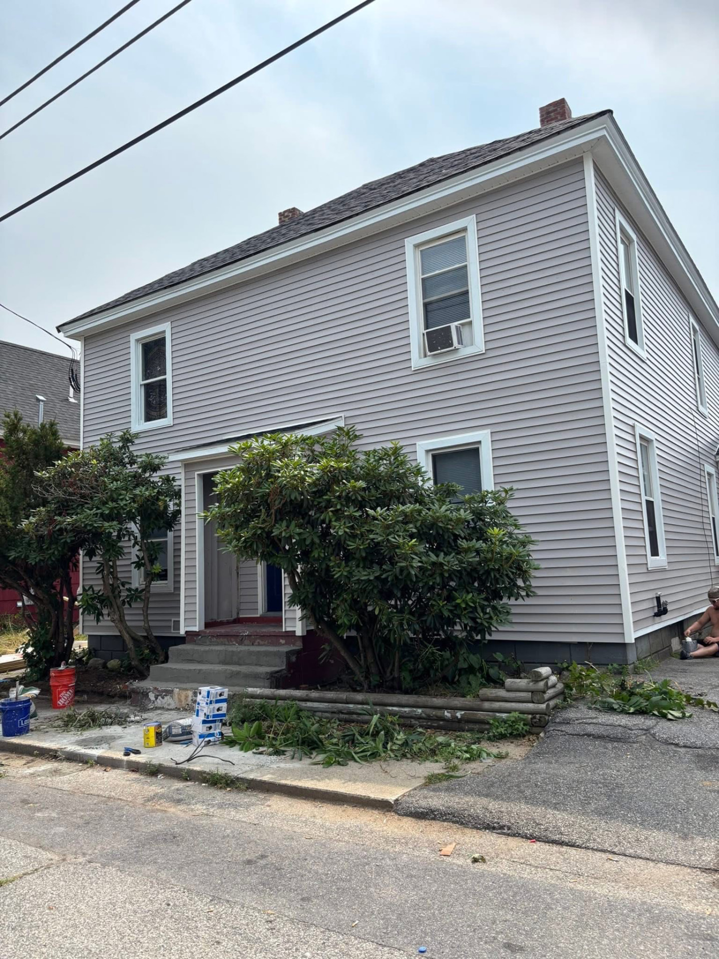 Historic home after full siding replacement with gray vinyl siding and white trim