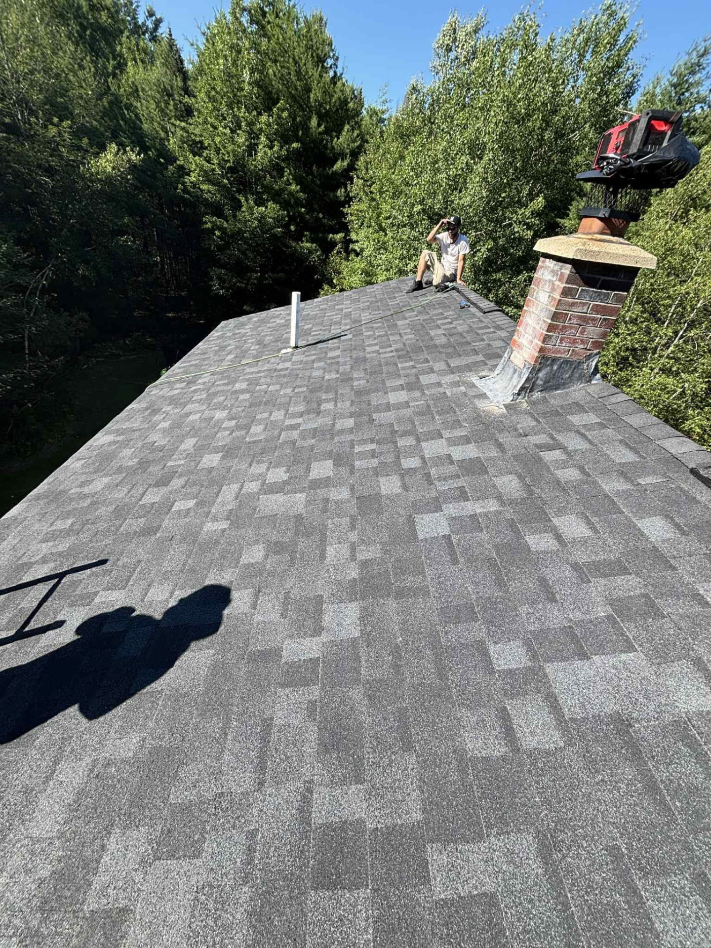 Professional roofer installing new asphalt shingles on a residential home